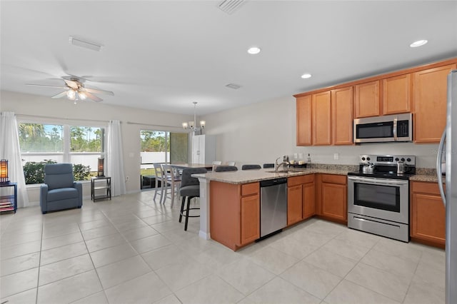 kitchen featuring a peninsula, a wealth of natural light, appliances with stainless steel finishes, and a sink