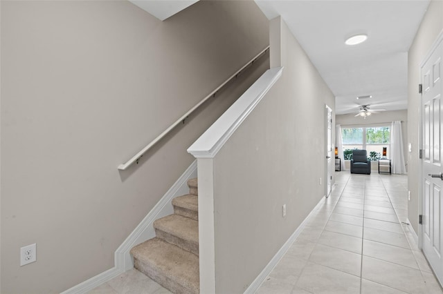 stairway with tile patterned flooring, ceiling fan, and baseboards