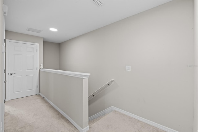 corridor featuring visible vents, baseboards, an upstairs landing, carpet flooring, and recessed lighting