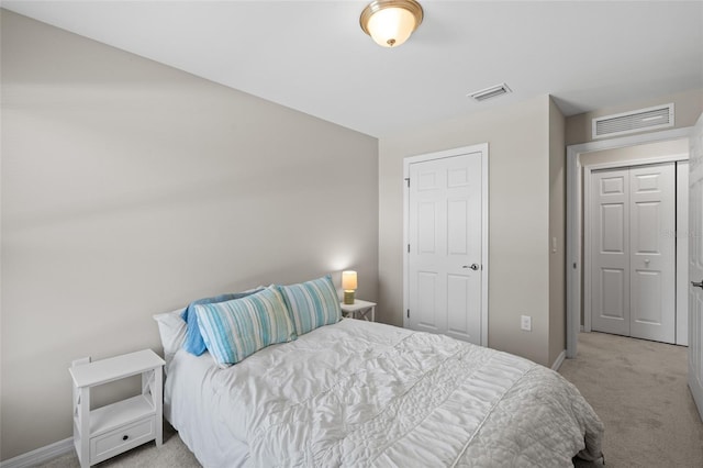 bedroom with visible vents, light carpet, and baseboards