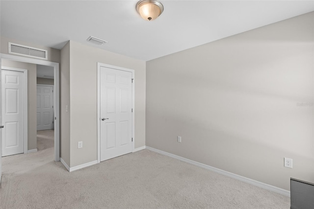 unfurnished bedroom featuring visible vents, carpet floors, and baseboards