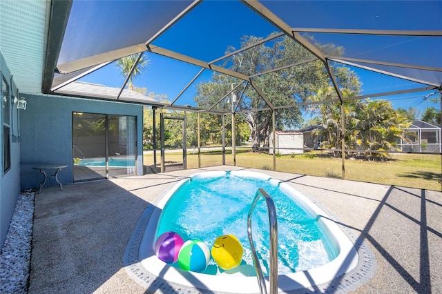 pool with glass enclosure, a yard, and a patio area