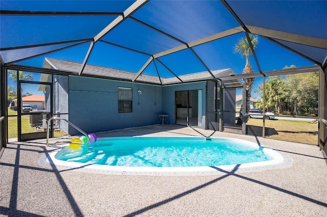 pool with glass enclosure and a patio