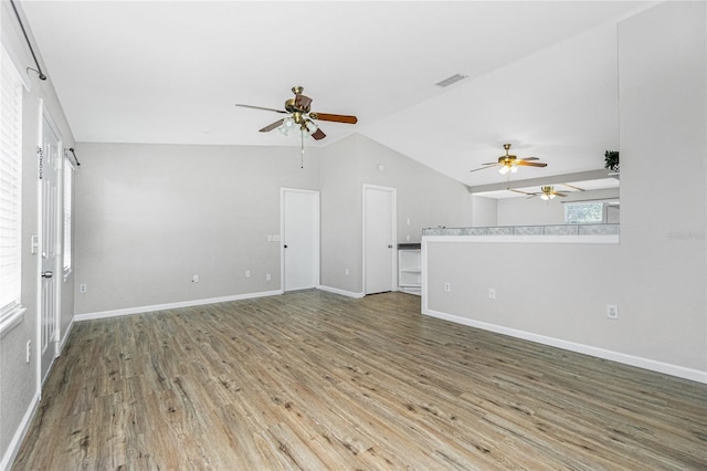 unfurnished living room with visible vents, a ceiling fan, wood finished floors, baseboards, and vaulted ceiling