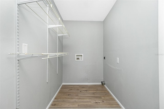 clothes washing area featuring wood finished floors, baseboards, hookup for an electric dryer, laundry area, and washer hookup