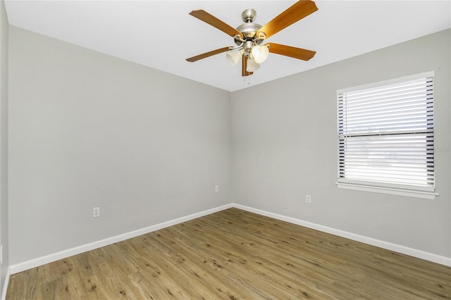 spare room with light wood finished floors, ceiling fan, and baseboards