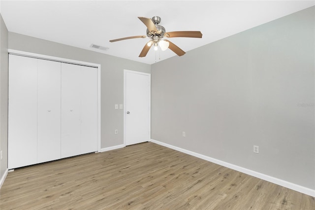 unfurnished bedroom with light wood-type flooring, visible vents, a closet, baseboards, and ceiling fan