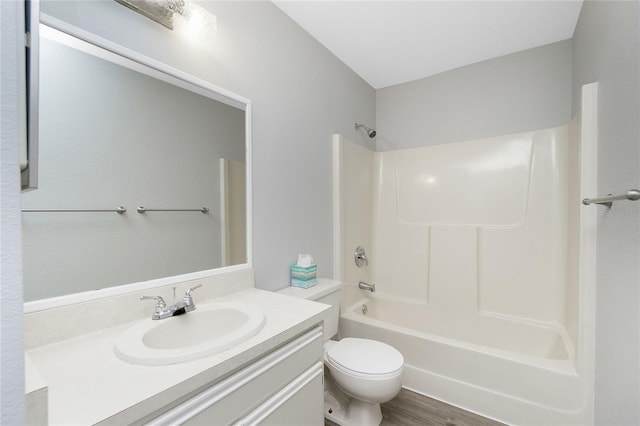 bathroom with wood finished floors, toilet, shower / washtub combination, and vanity