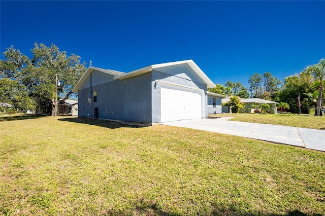 view of side of home with a garage, a yard, and driveway