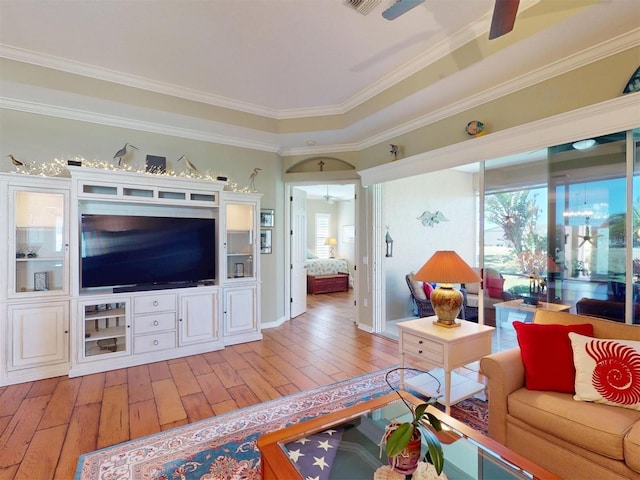 living area with light wood-type flooring, arched walkways, a ceiling fan, and crown molding