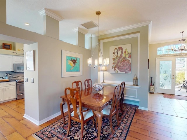 dining space featuring baseboards, light wood-style floors, an inviting chandelier, and ornamental molding