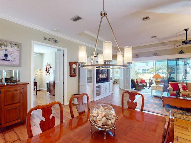 dining area with crown molding, a ceiling fan, visible vents, and light wood-type flooring