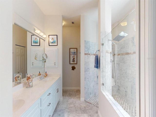 bathroom with baseboards, double vanity, a sink, a walk in shower, and marble finish floor