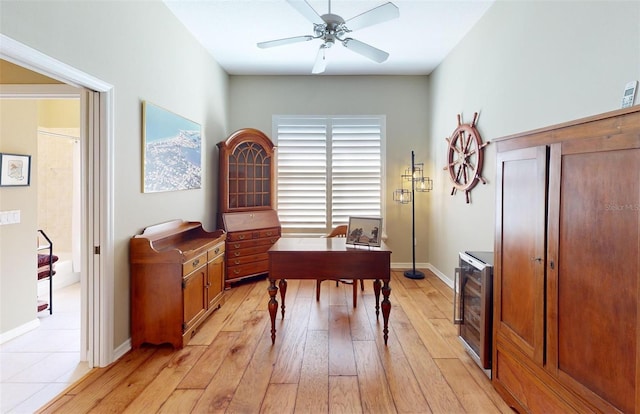 office featuring baseboards, wine cooler, ceiling fan, and light wood finished floors