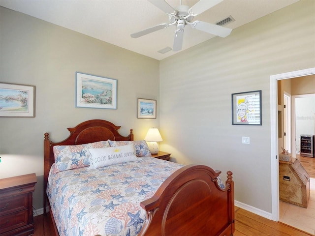 bedroom with visible vents, beverage cooler, a ceiling fan, wood finished floors, and baseboards