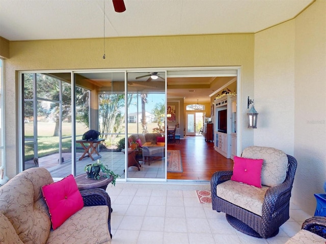 sunroom / solarium featuring a ceiling fan