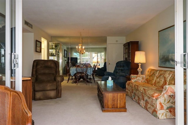 living area with visible vents, light colored carpet, and a chandelier