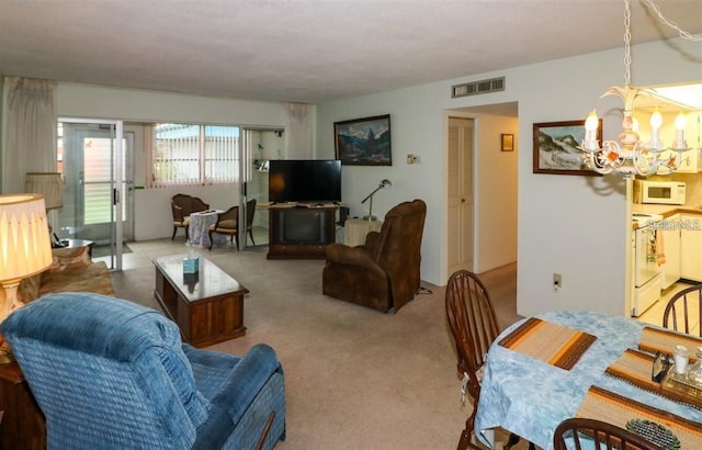 living room featuring a notable chandelier, visible vents, and carpet