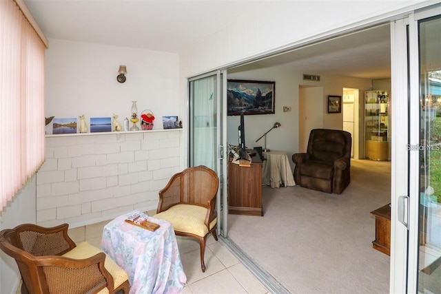 living area featuring tile patterned flooring, visible vents, and carpet floors