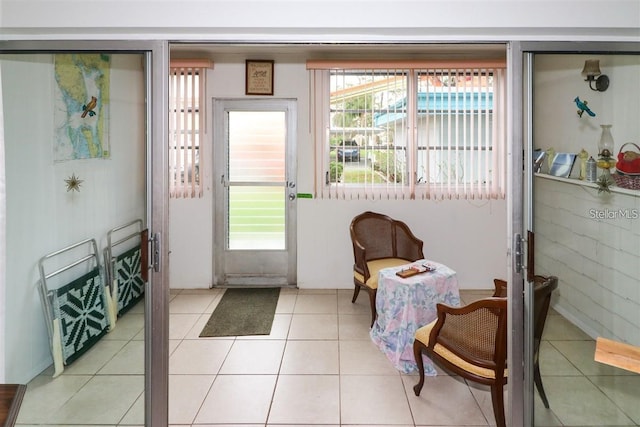 doorway to outside featuring light tile patterned floors and a healthy amount of sunlight