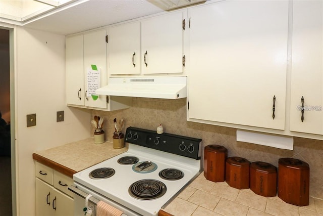 kitchen featuring white range with electric cooktop, light countertops, under cabinet range hood, tile patterned floors, and tasteful backsplash