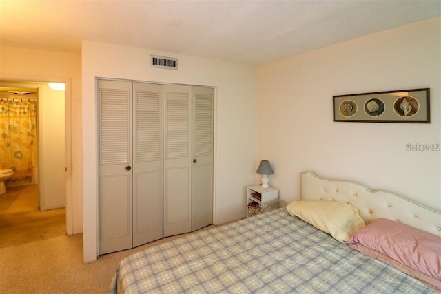 bedroom featuring visible vents, a closet, and light carpet