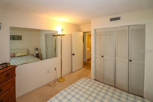 carpeted bedroom featuring visible vents and a closet