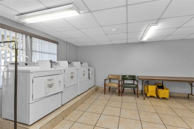 community laundry room featuring light tile patterned floors and washing machine and clothes dryer