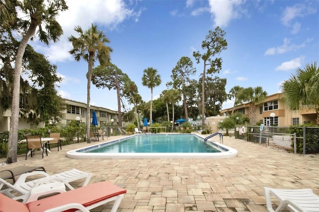 pool with a patio area and fence