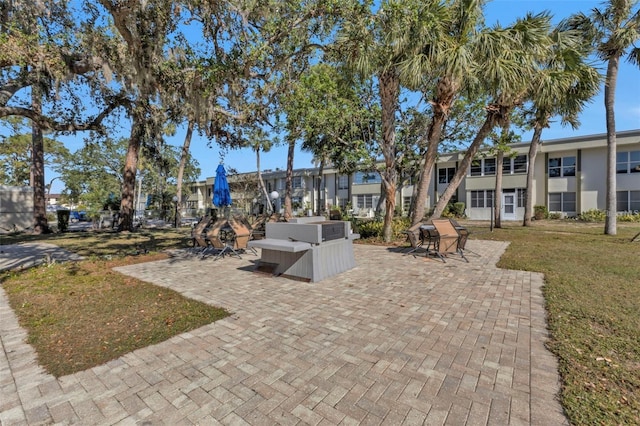 view of property's community with a patio and a lawn