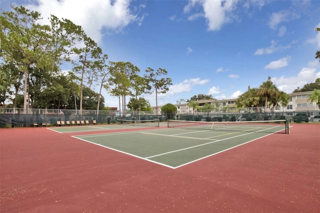 view of tennis court featuring community basketball court and fence