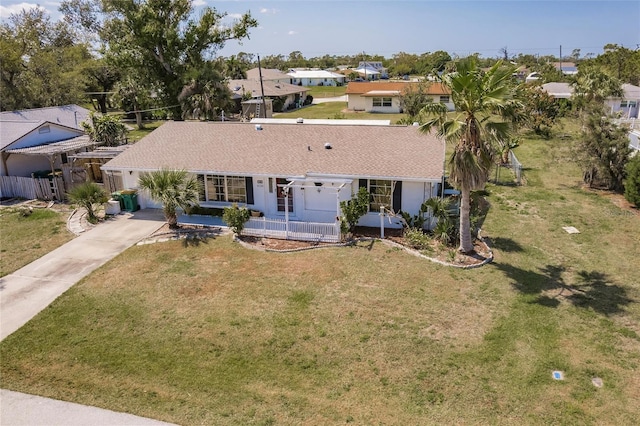 single story home with concrete driveway and a front yard