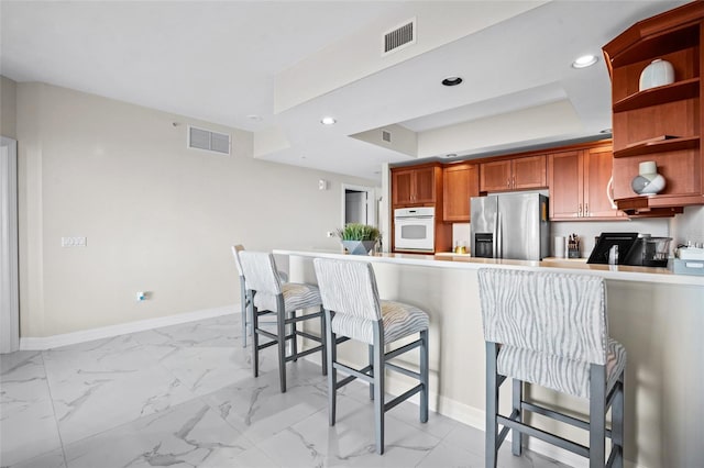 kitchen featuring visible vents, white oven, stainless steel fridge, marble finish floor, and open shelves