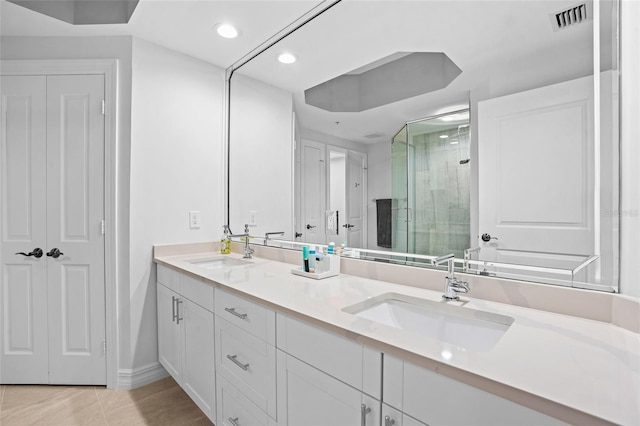 bathroom with double vanity, visible vents, a shower stall, and a sink