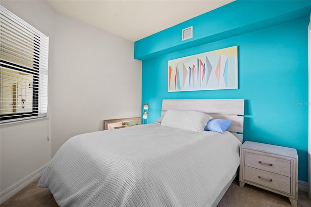 bedroom featuring visible vents, baseboards, and carpet