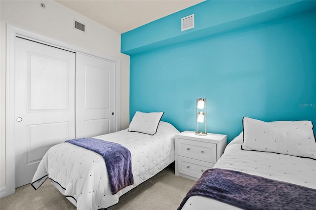 bedroom featuring visible vents, carpet, and a closet