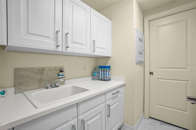 washroom with baseboards, marble finish floor, and a sink