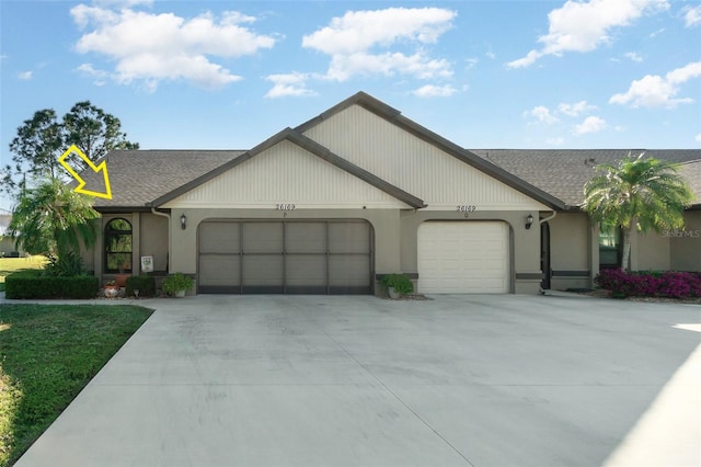 view of front of property featuring a garage, driveway, and a shingled roof