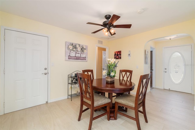 dining room with visible vents, arched walkways, baseboards, and ceiling fan