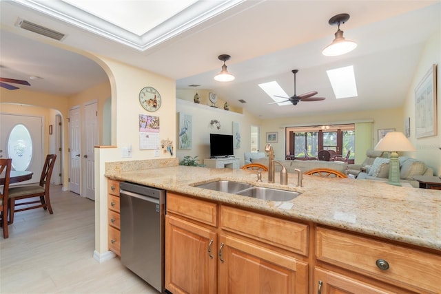 kitchen with a sink, visible vents, light stone counters, and dishwasher