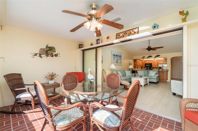 dining room with visible vents, arched walkways, a ceiling fan, and vaulted ceiling