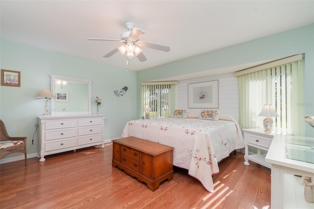 bedroom featuring baseboards, light wood-style flooring, and a ceiling fan