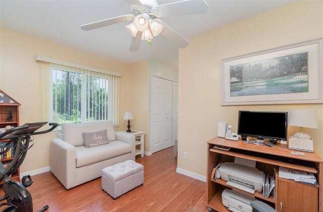 office space with light wood-type flooring, baseboards, and a ceiling fan