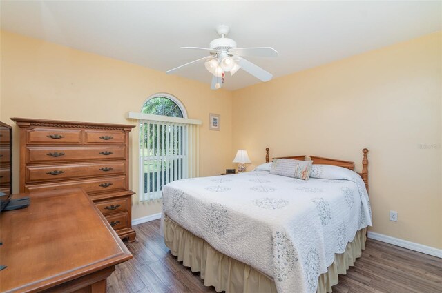 bedroom with baseboards, wood finished floors, a ceiling fan, and access to outside