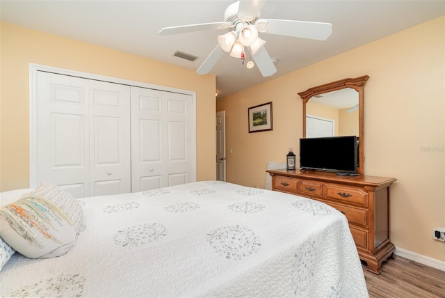 bedroom featuring light wood finished floors, visible vents, baseboards, a closet, and a ceiling fan