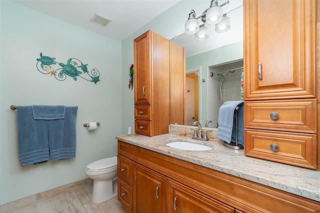 bathroom with visible vents, toilet, walk in shower, and vanity