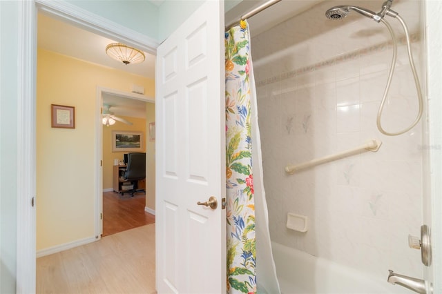 bathroom featuring shower / tub combo, baseboards, and wood finished floors