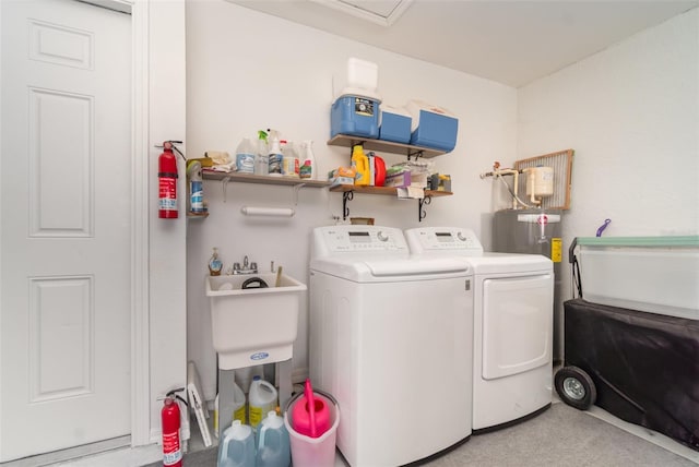 clothes washing area with washer and dryer, laundry area, and a sink