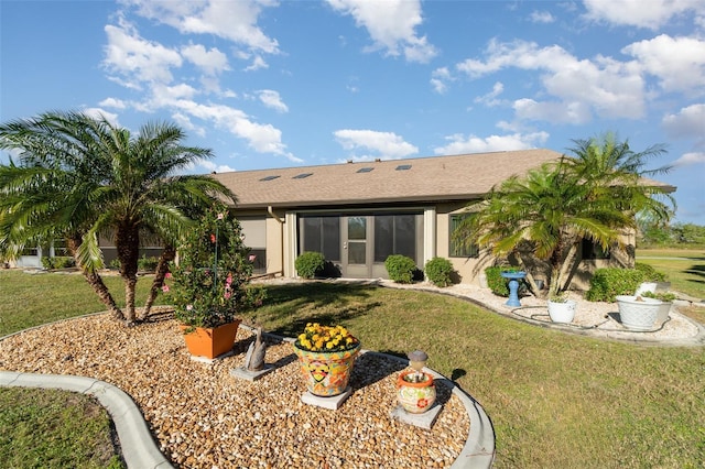 back of property featuring a lawn and stucco siding