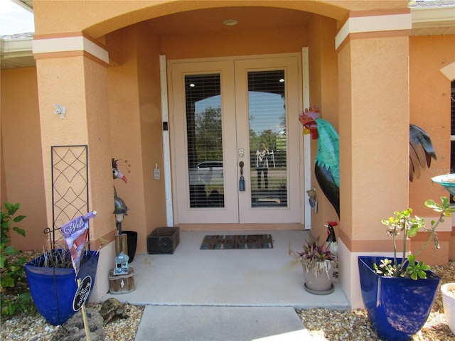 doorway to property featuring stucco siding and french doors